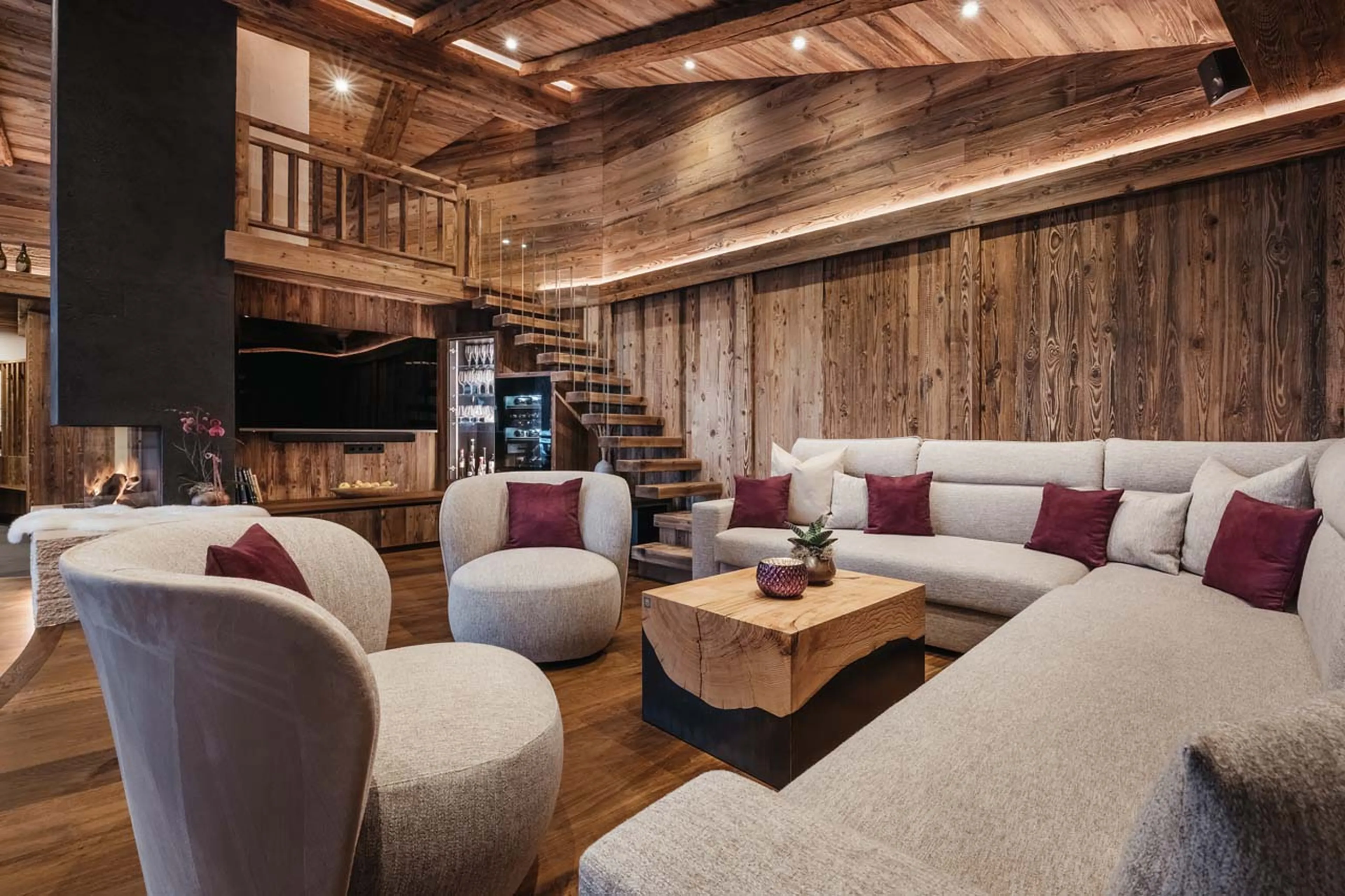 Wrap-around sofa, armchairs and central fireplace in Chalet Robin, Val Gardena