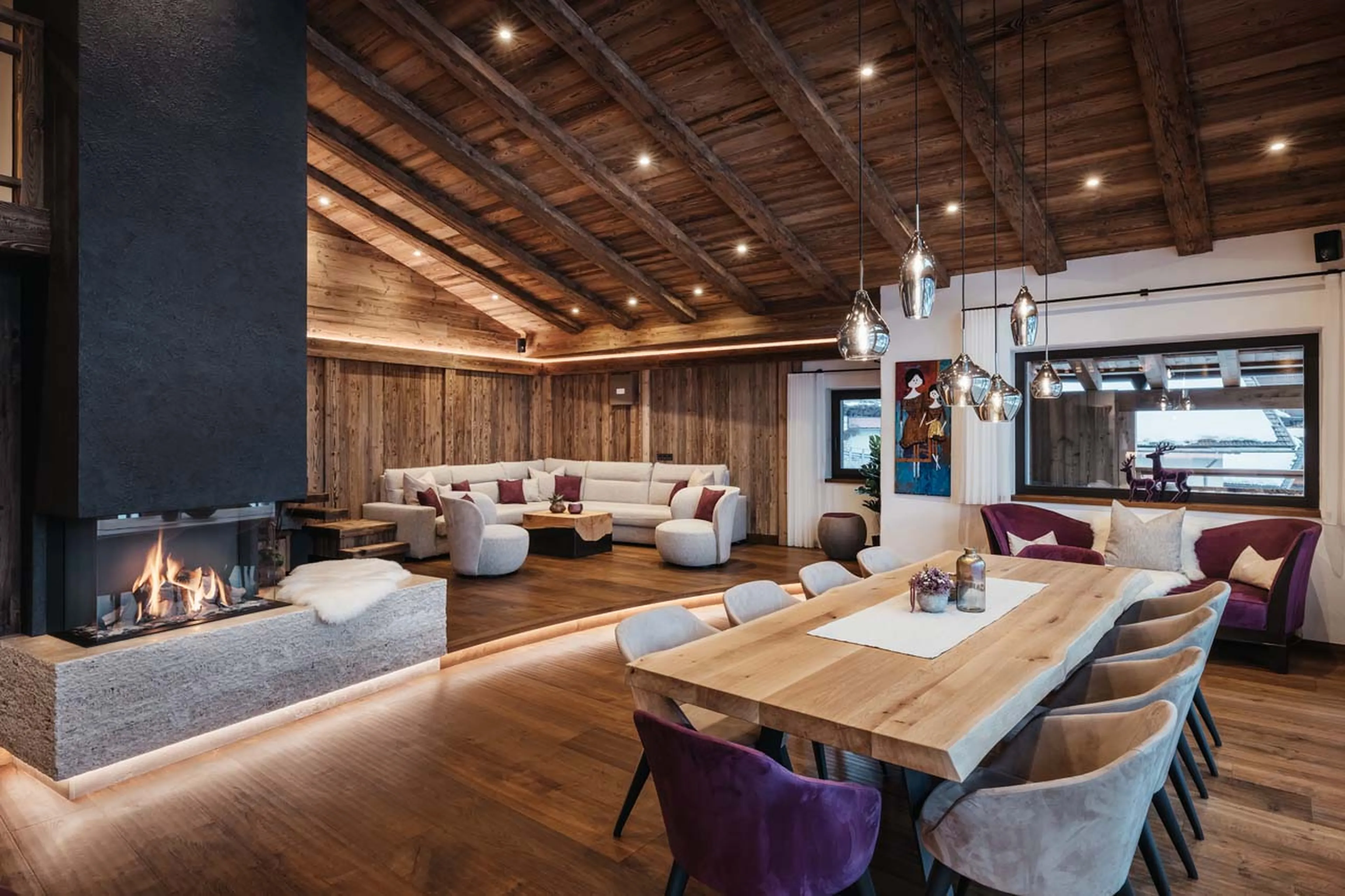 Central fireplace and large dining table in Chalet Robin, Val Gardena