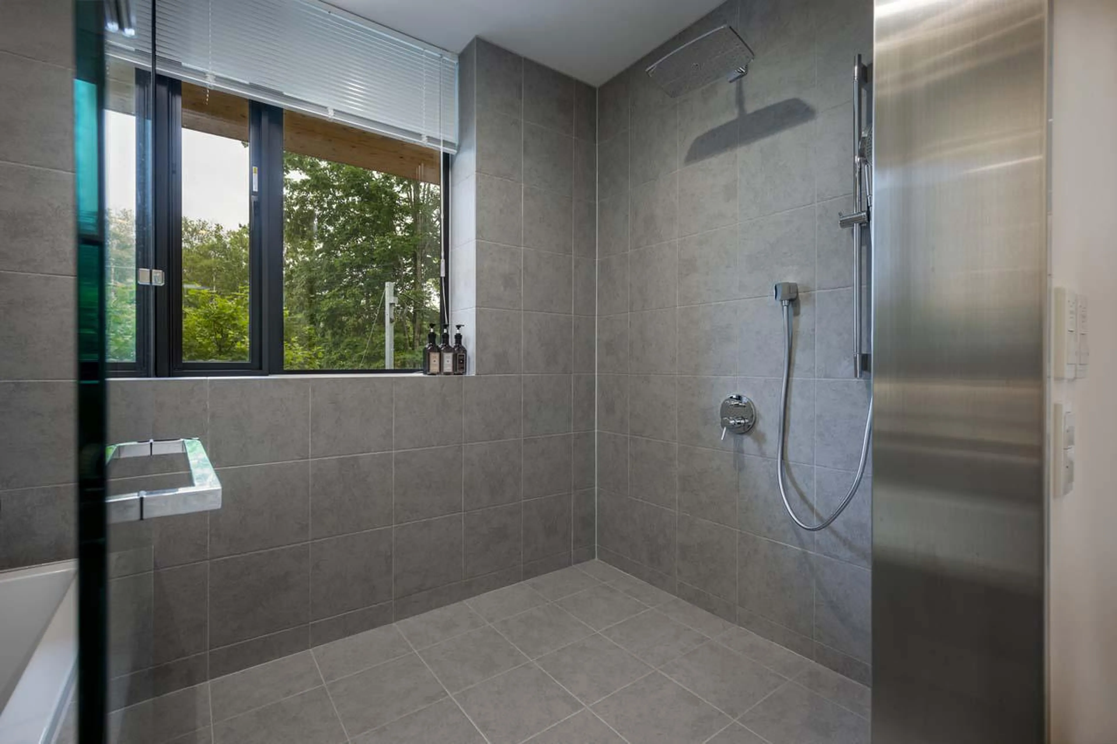 En-suite bathroom with bath and separate shower at Chalet Ryoun in Niseko