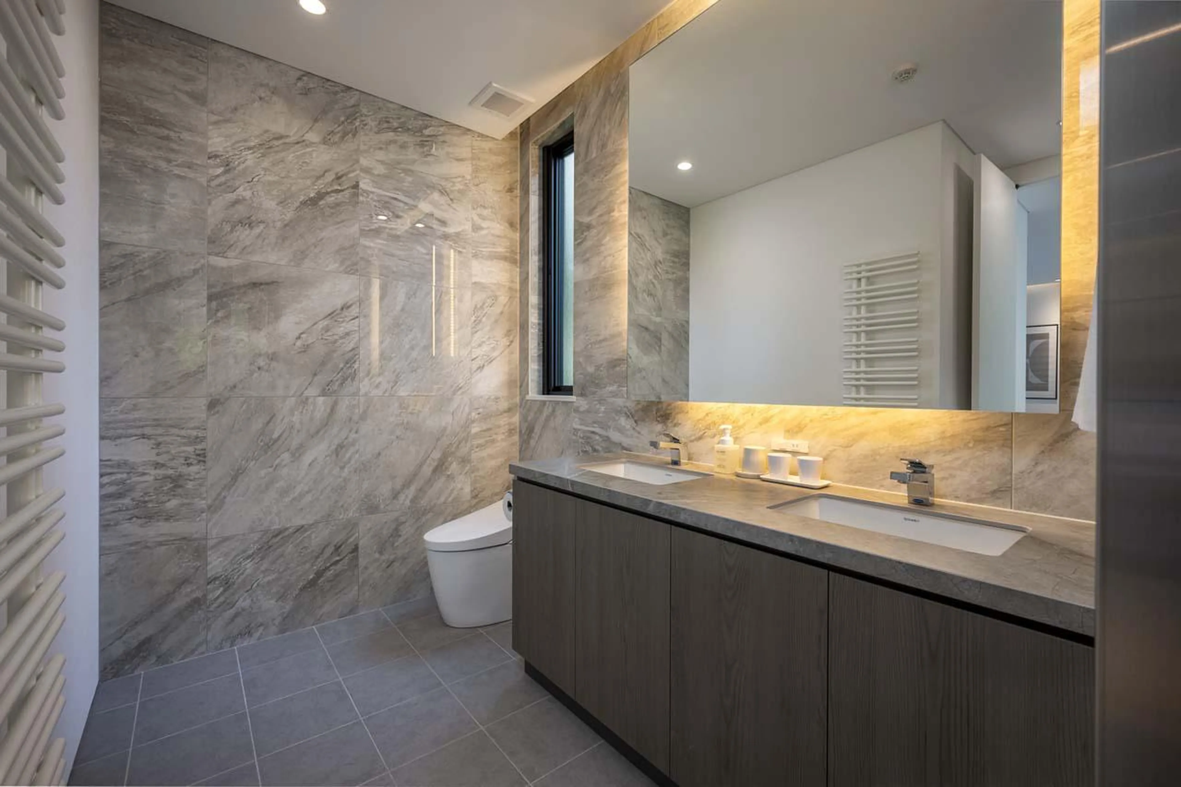 Modern en-suite bathroom with double basin, bath and shower at Chalet Ryoun in Niseko