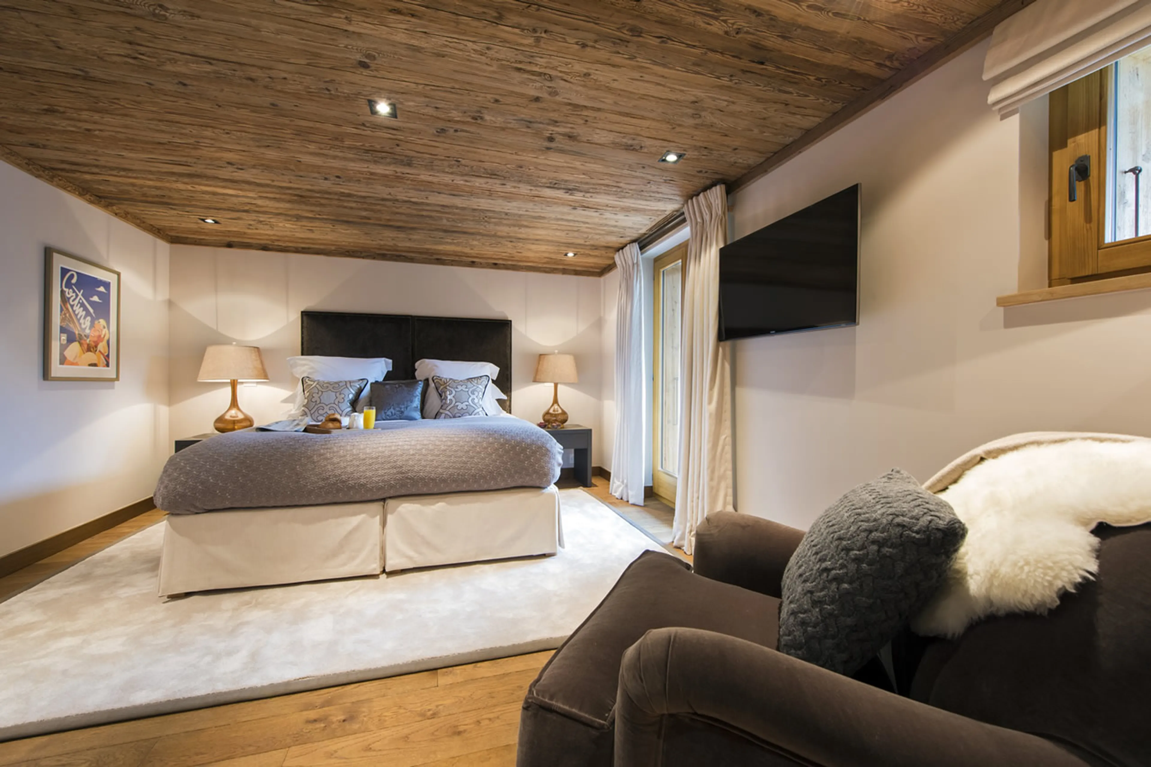 Armchair and TV in master bedroom in Chalet Sirocco in Verbier