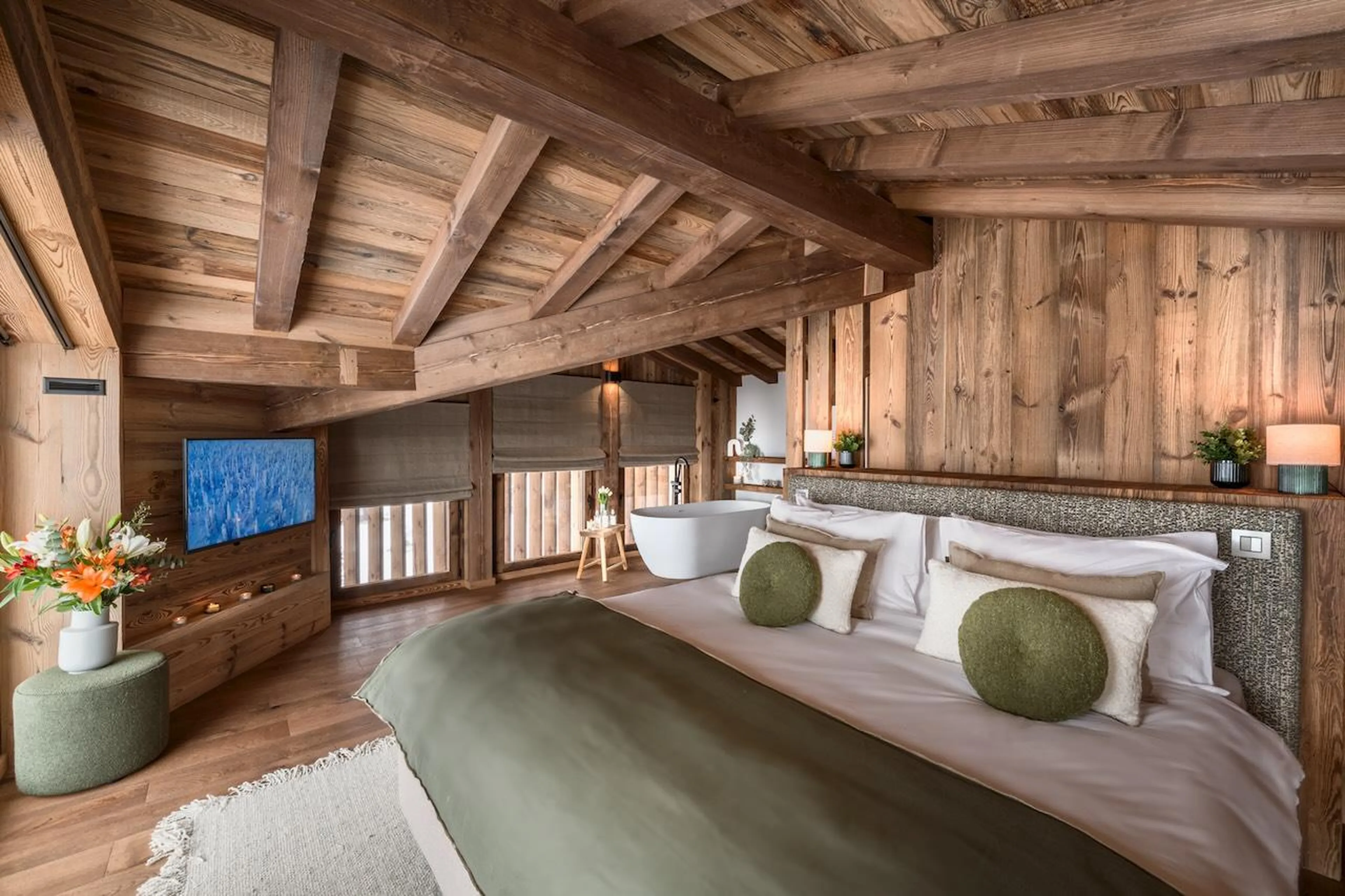 Spacious master bedroom with wood-beamed ceiling at Chalet Tosca in Les Gets