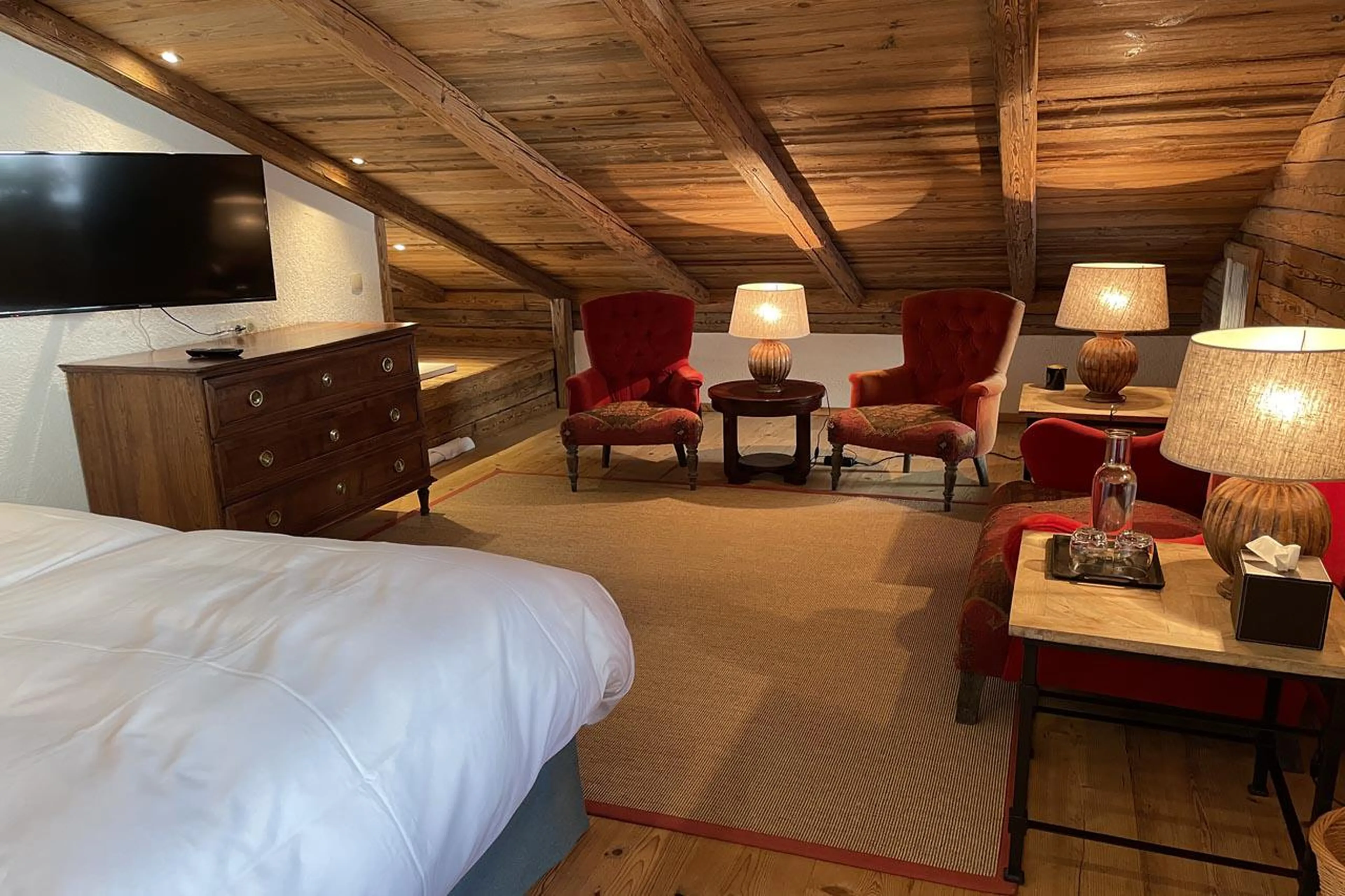 Double bedroom with TV and sofa area at Chalet Tschoder in St Anton