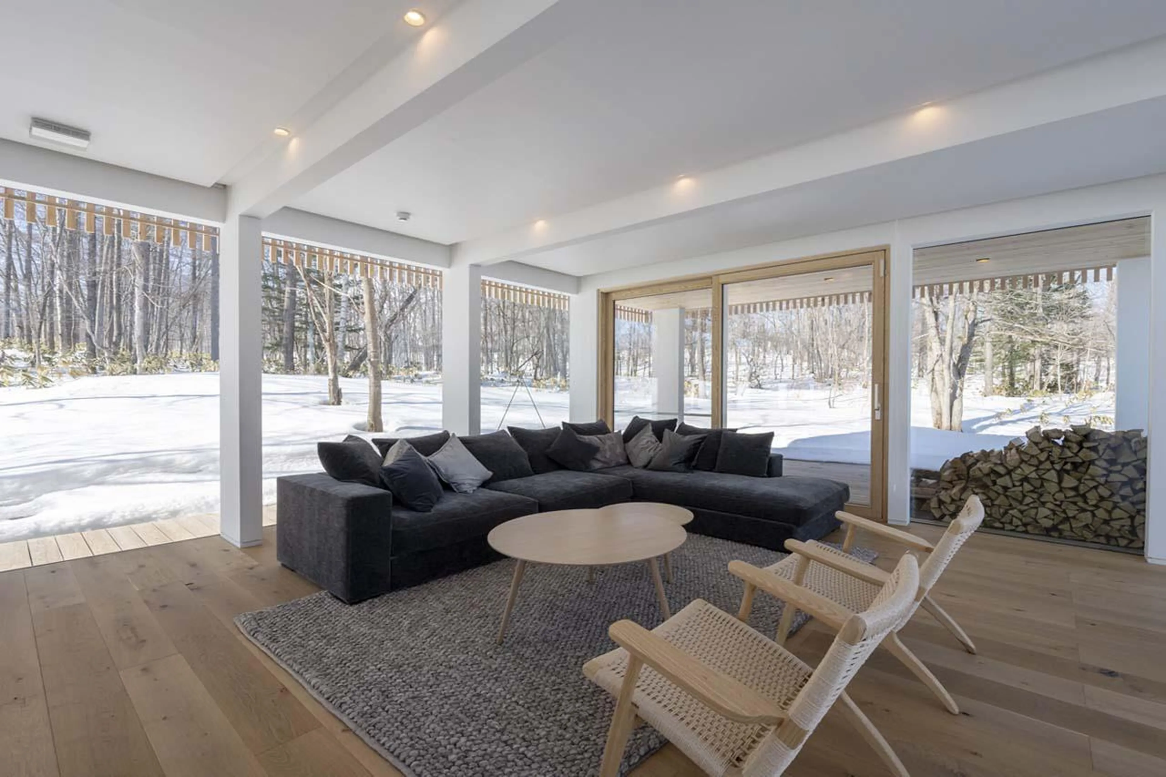 Cosy sofa corner surrounded by floor-to-ceiling windows at Chalet Yukihyo in Niseko