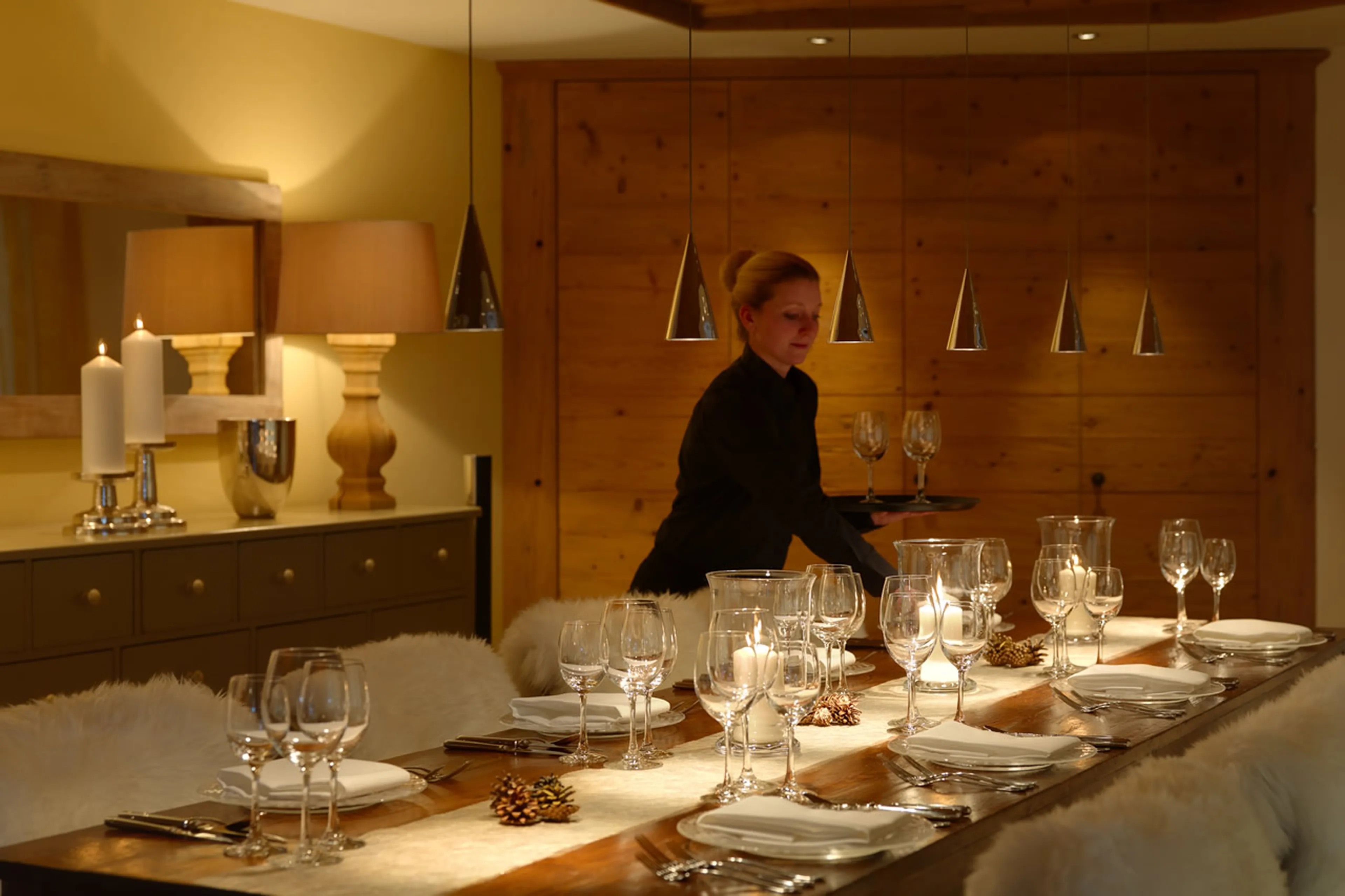 Dining room being laid for dinner at Chesa Falcun in Klosters.