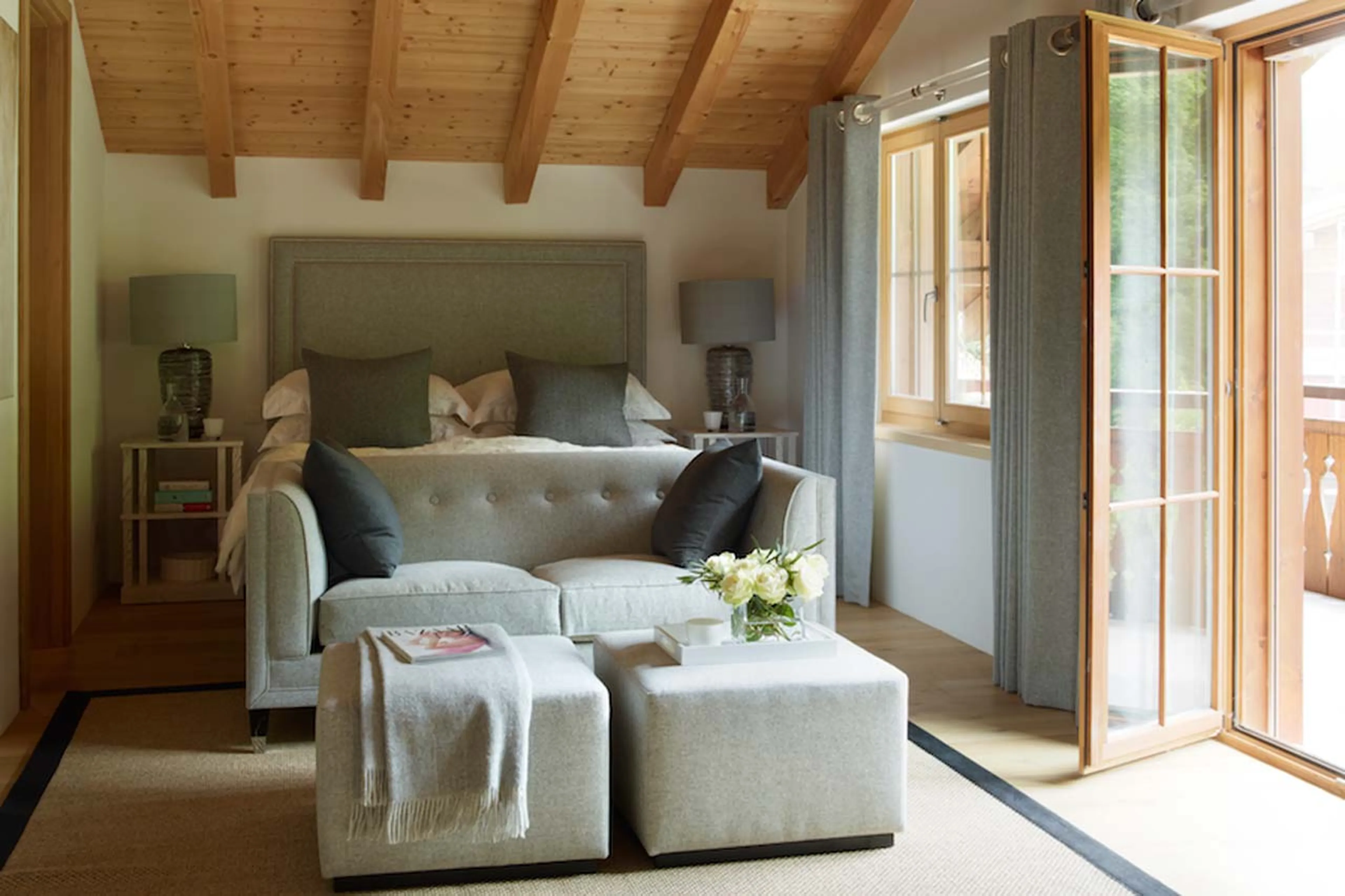 Super king size bed and comfortable seating in en-suite bedroom of Haus Alpina in Klosters