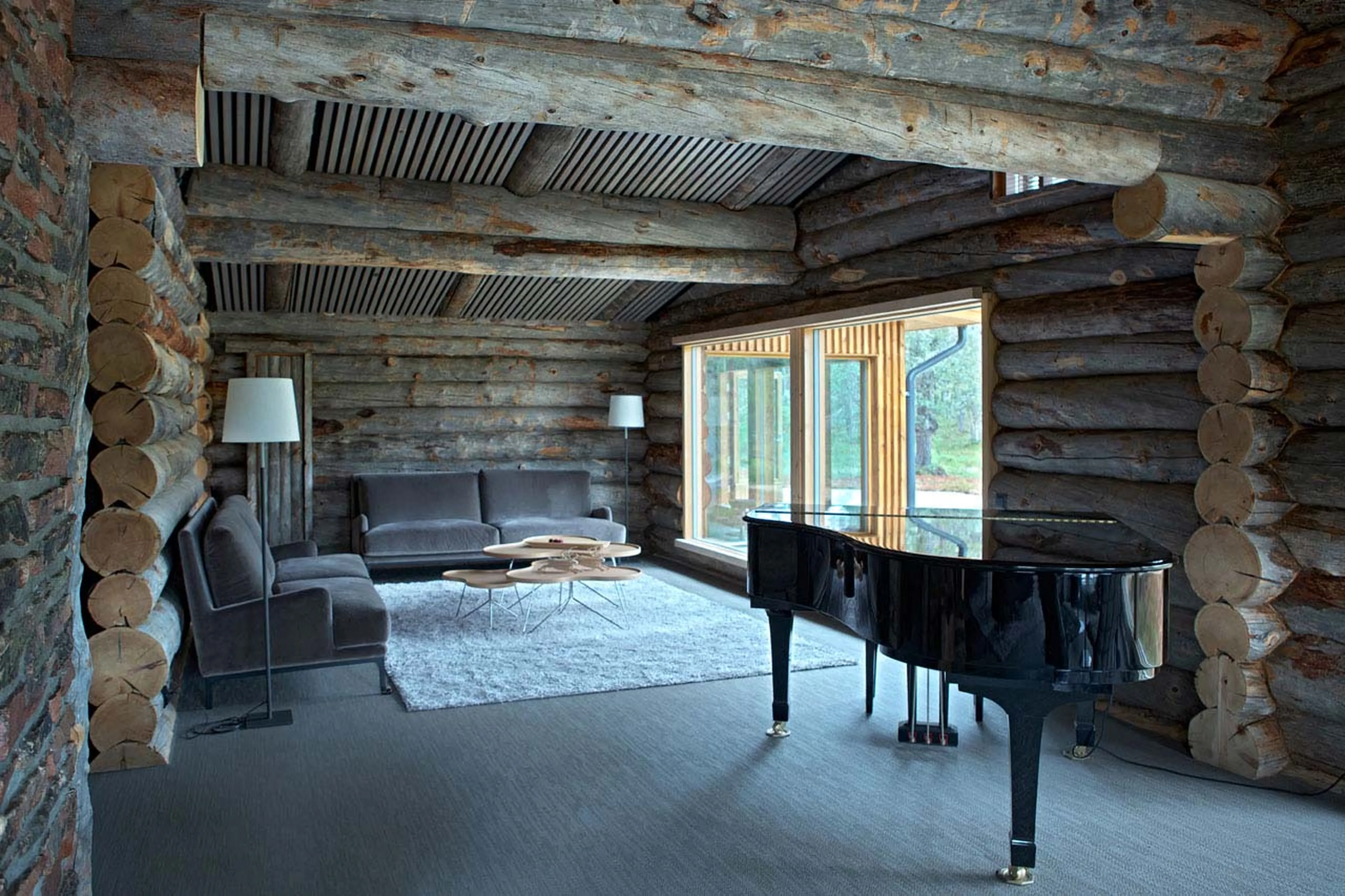 Piano and sofas in living room of Javri Lodge in Finland