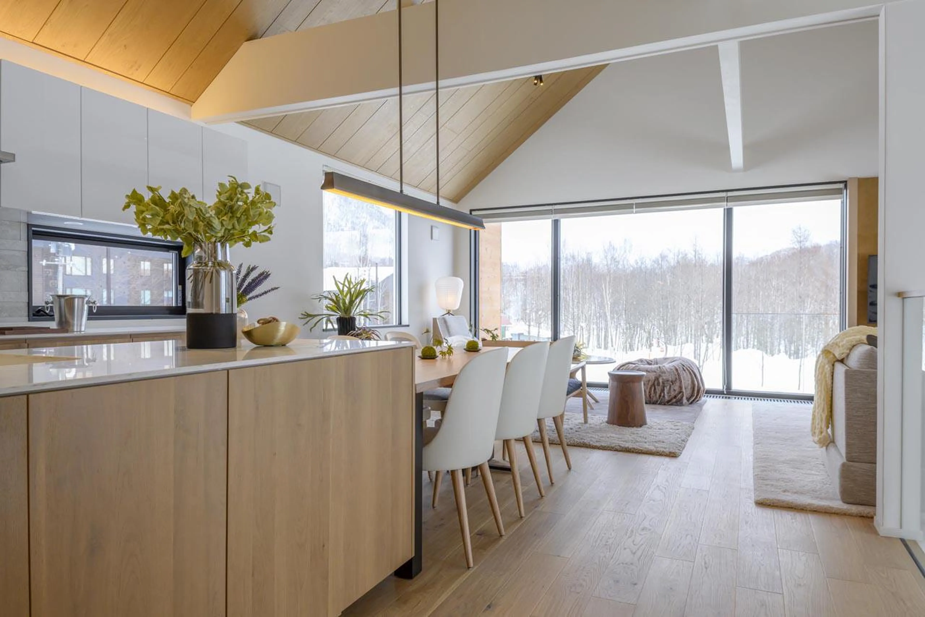 Snowy forest views from the kitchen and dining area at Koa Villa in Niseko