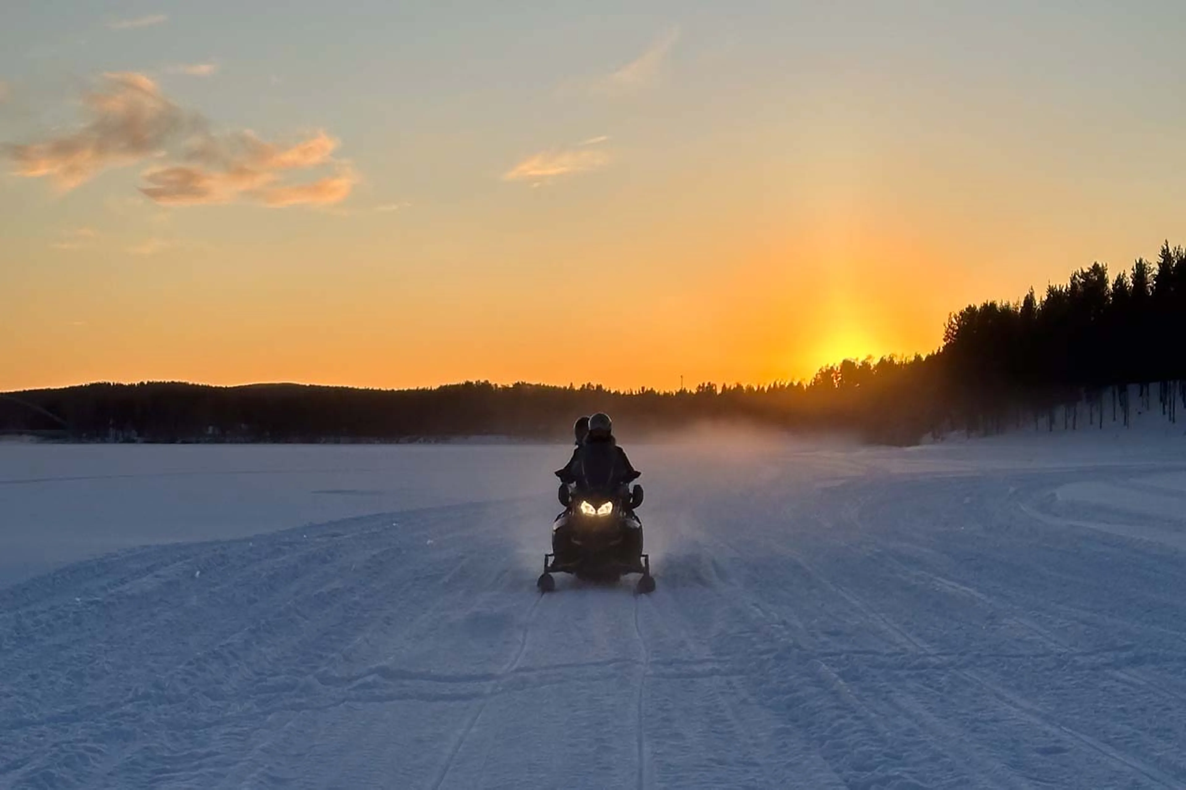 Snowmobiling at sunset at Logger's Lodge in Sweden
