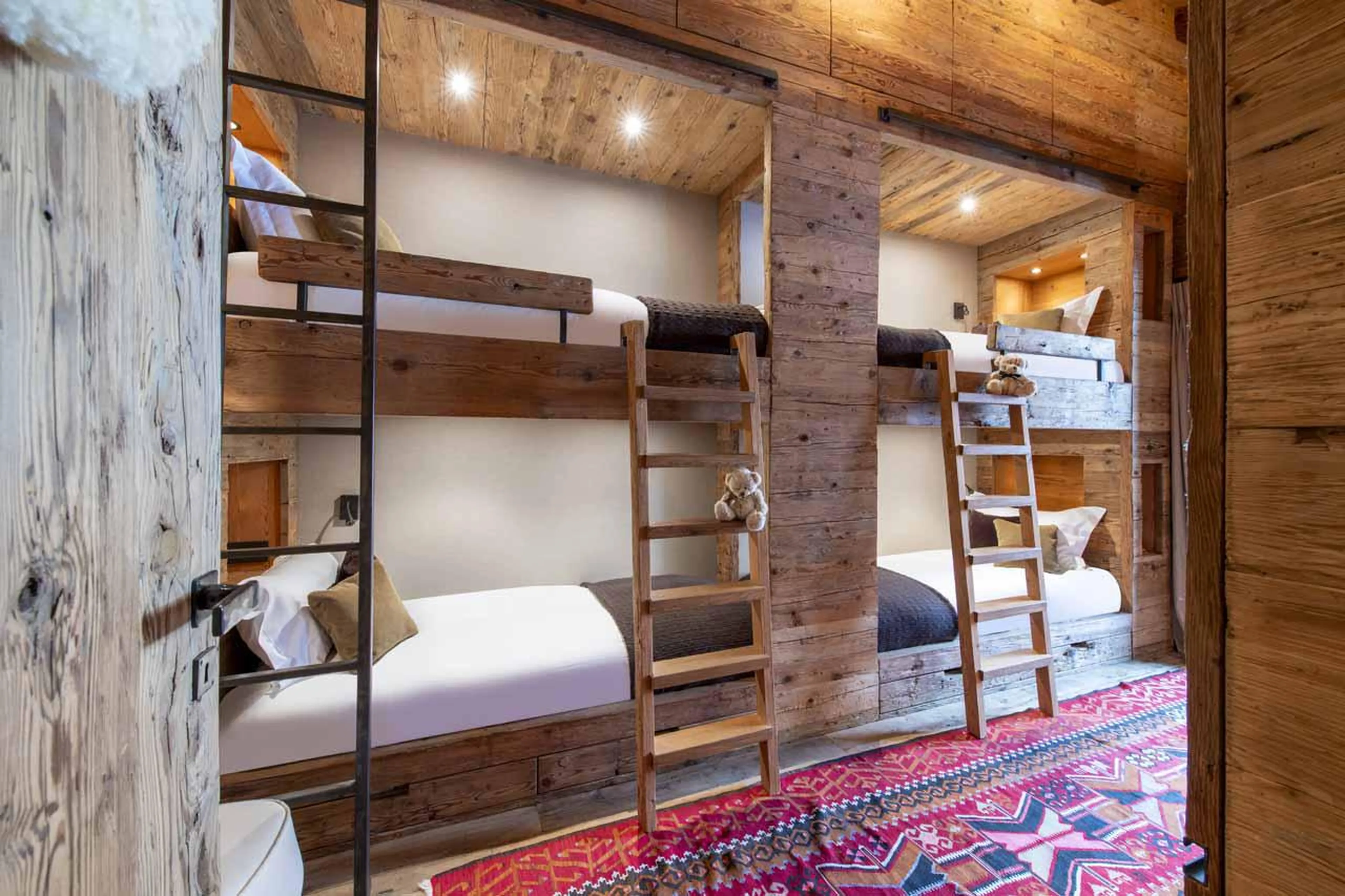 Quad bunk bedroom with desk and access to balcony at Marmotte Penthouse in Verbier