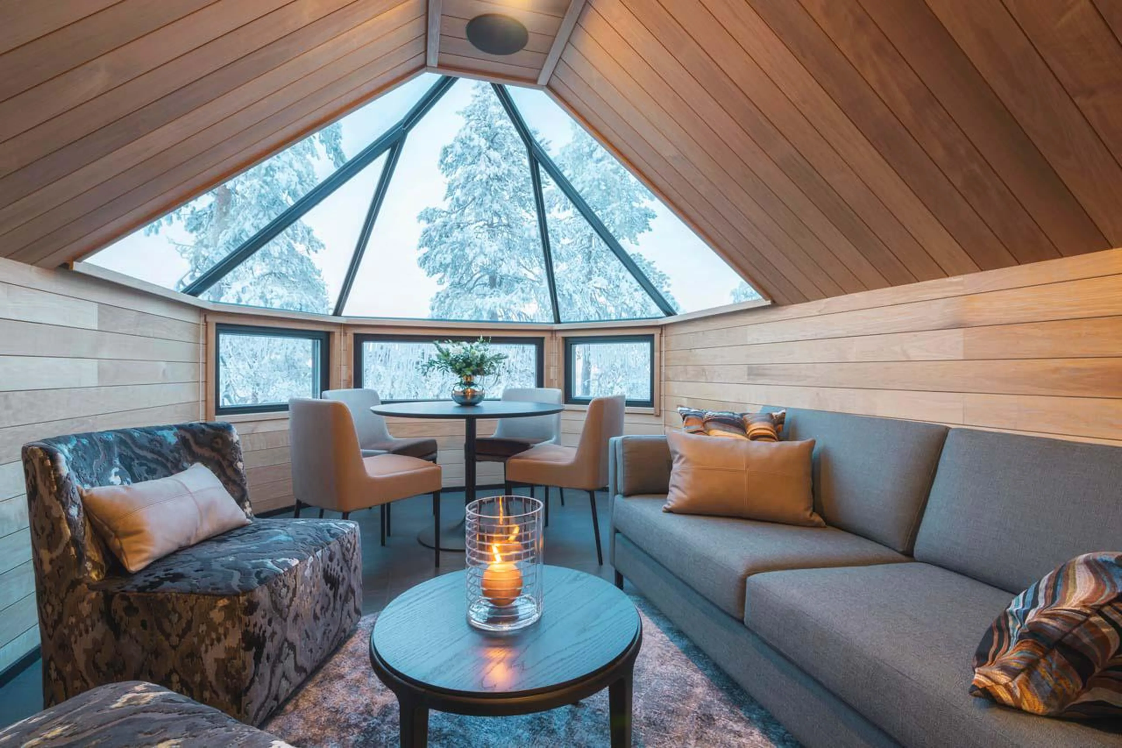 Private lounge with sofa area and dining table at Octola Glass Igloo in Finland