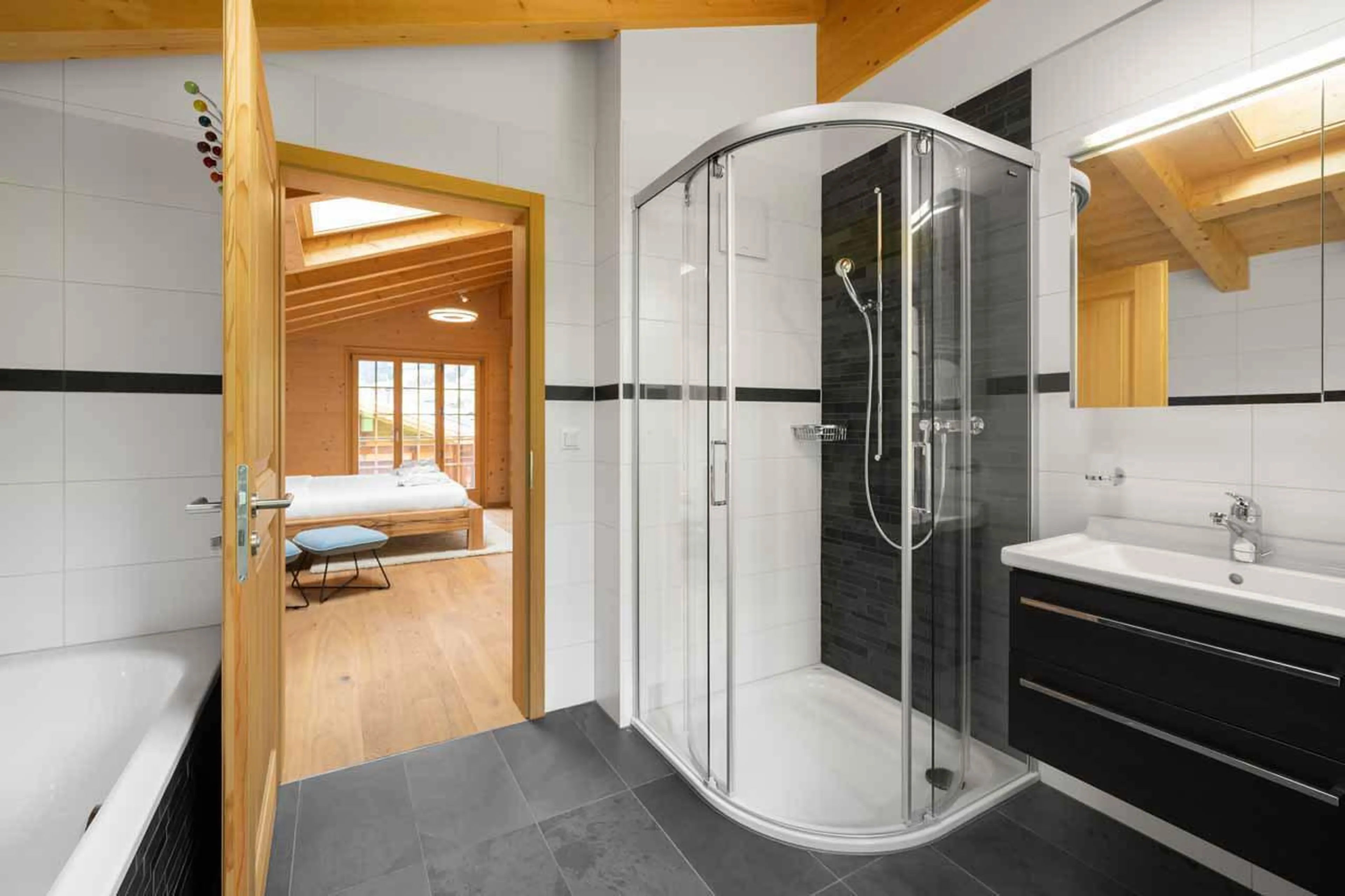 En-suite bathroom with bath and shower at Chalet Alia in Grindelwald