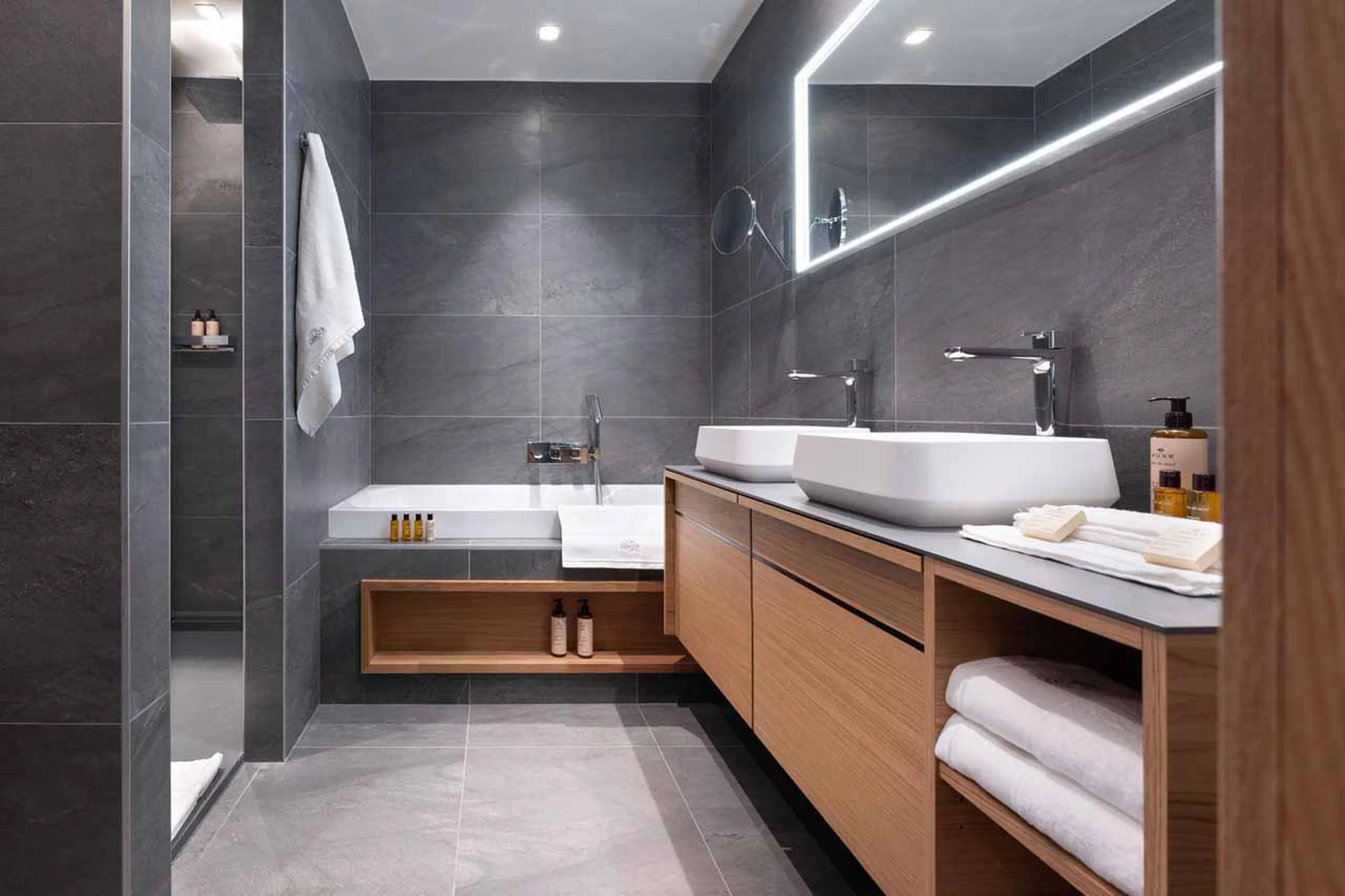 En-suite bathroom with bath, shower and integrated sound system at Chalet Arpoza in Les Arcs