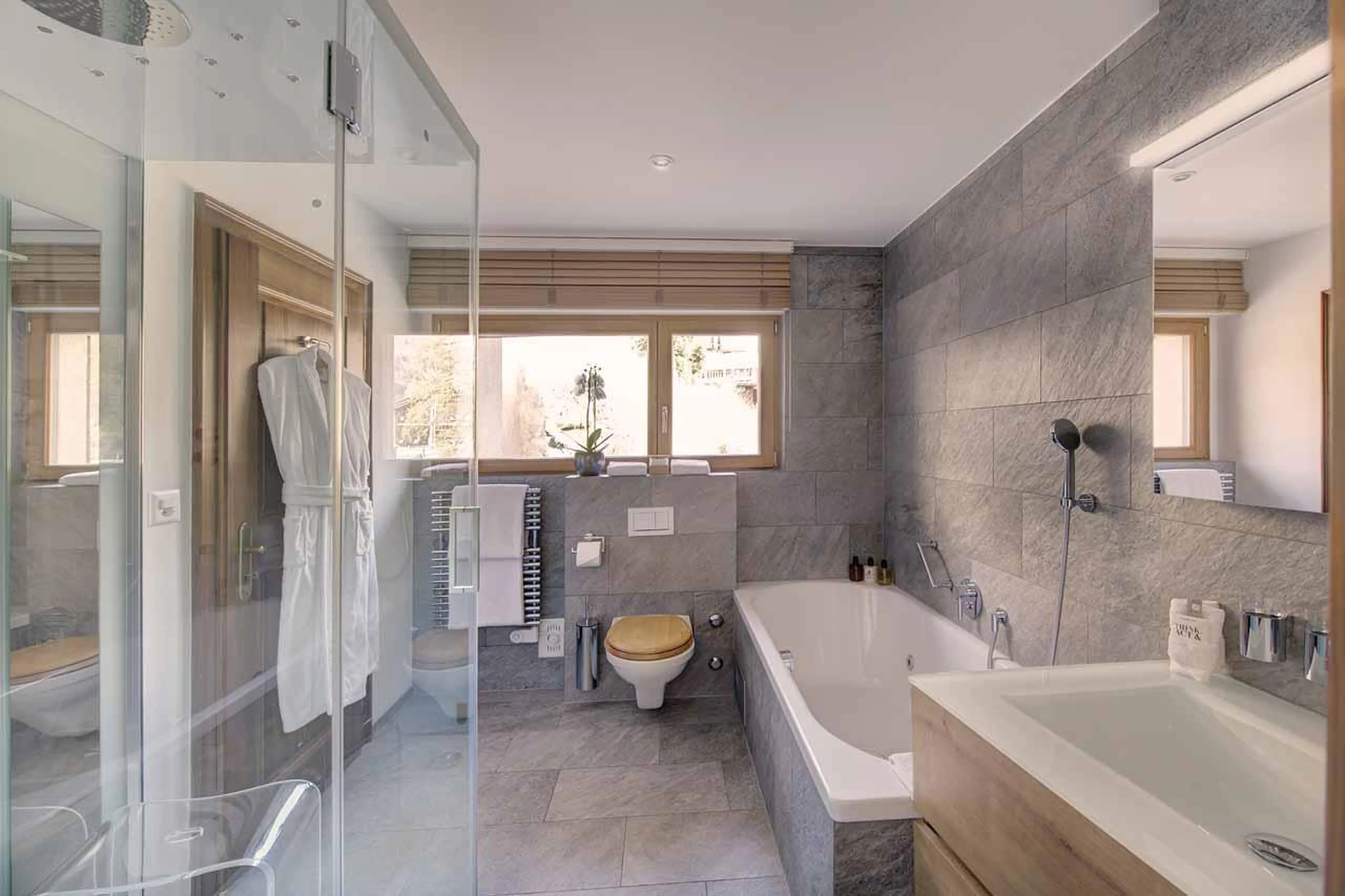 En-suite bathroom with jacuzzi bath and steam shower at Penthouse Zen in Zermatt