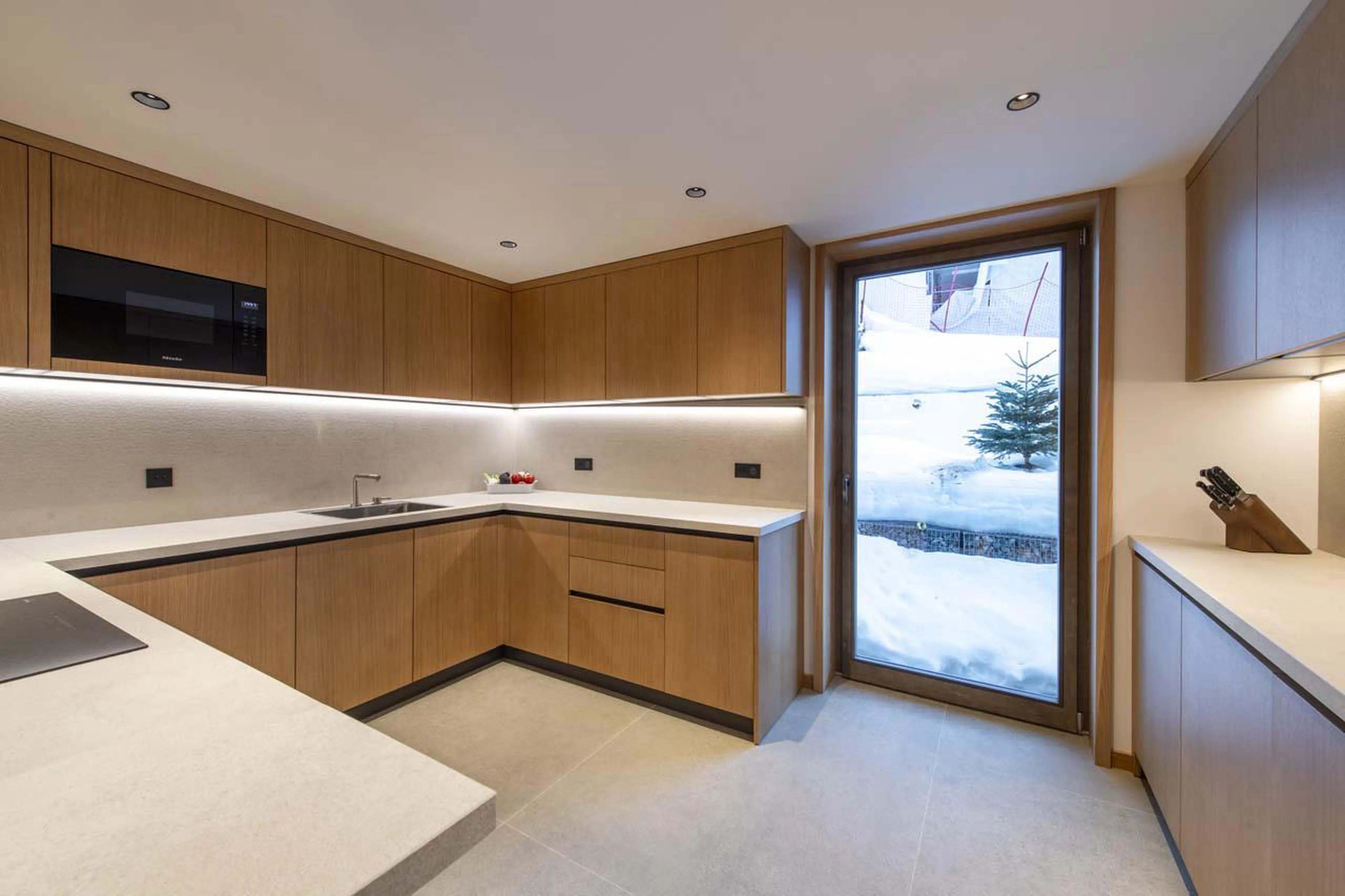 Sleek kitchen with grey wrap-around countertops at Sasha Apartment 4 in Courchevel 1850