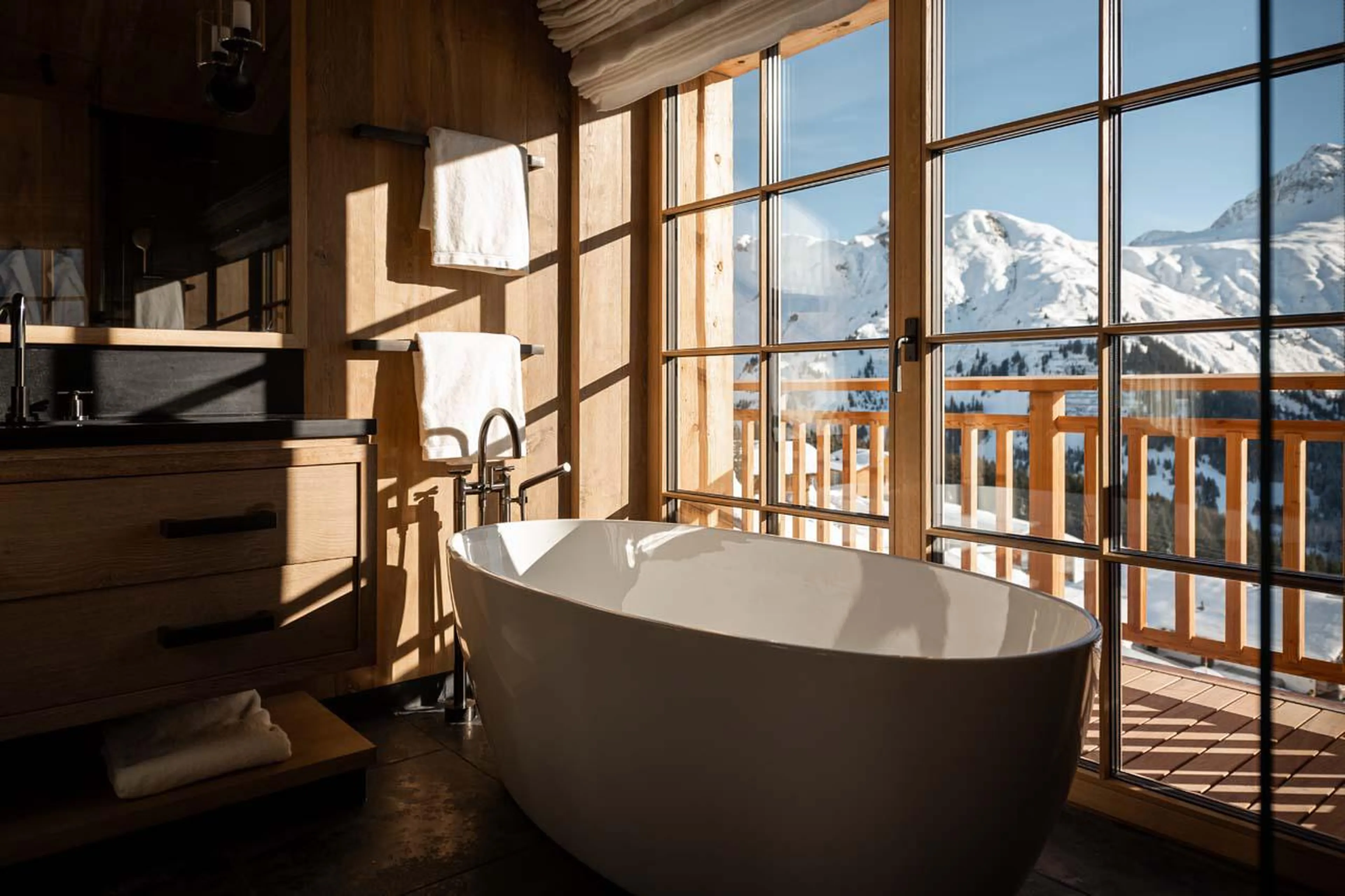 En-suite bathroom with views over the mountain peaks at The Barn in Lech