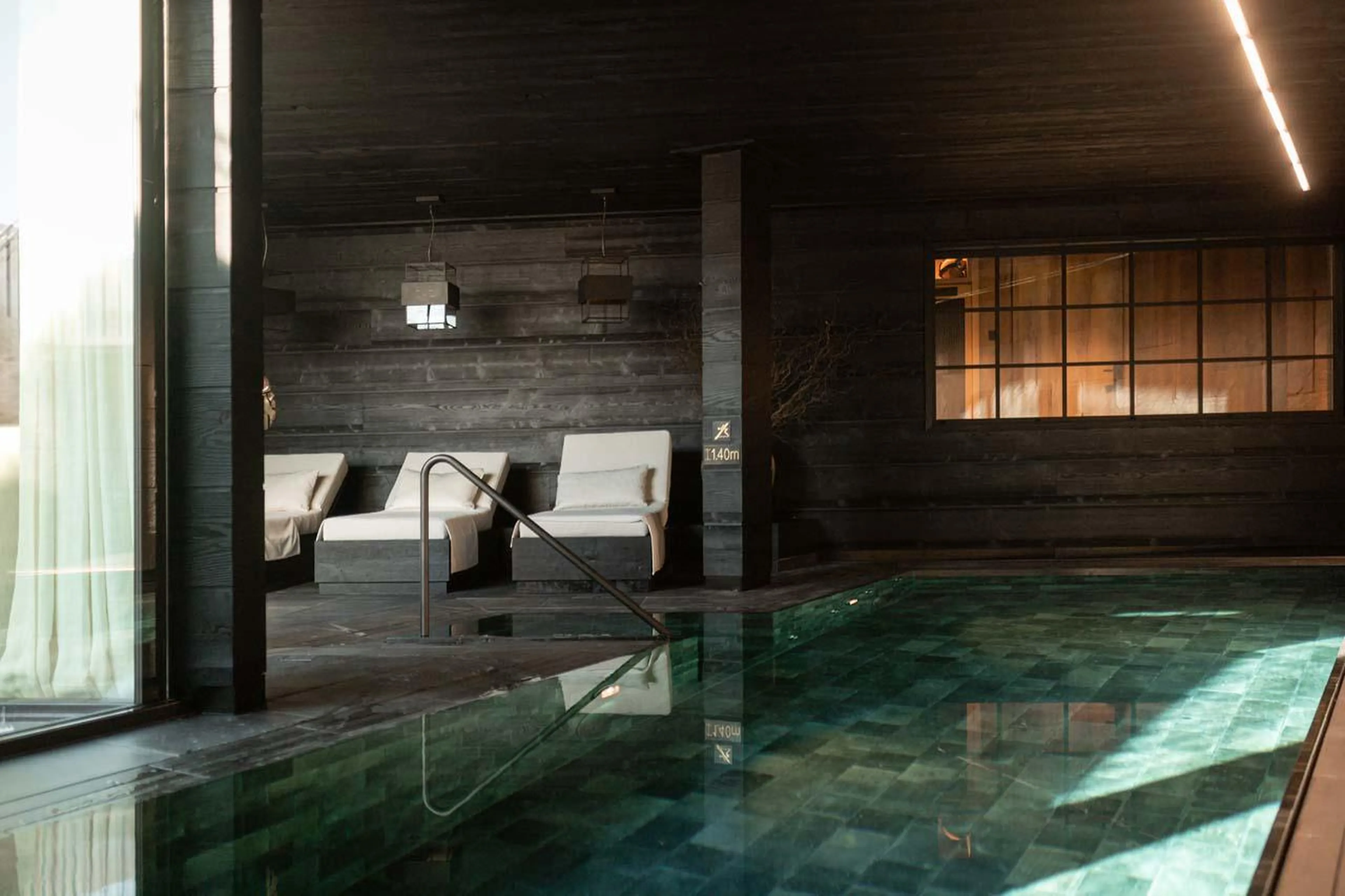 Loungers overlooking the indoor swimming pool at The Barn in Lech