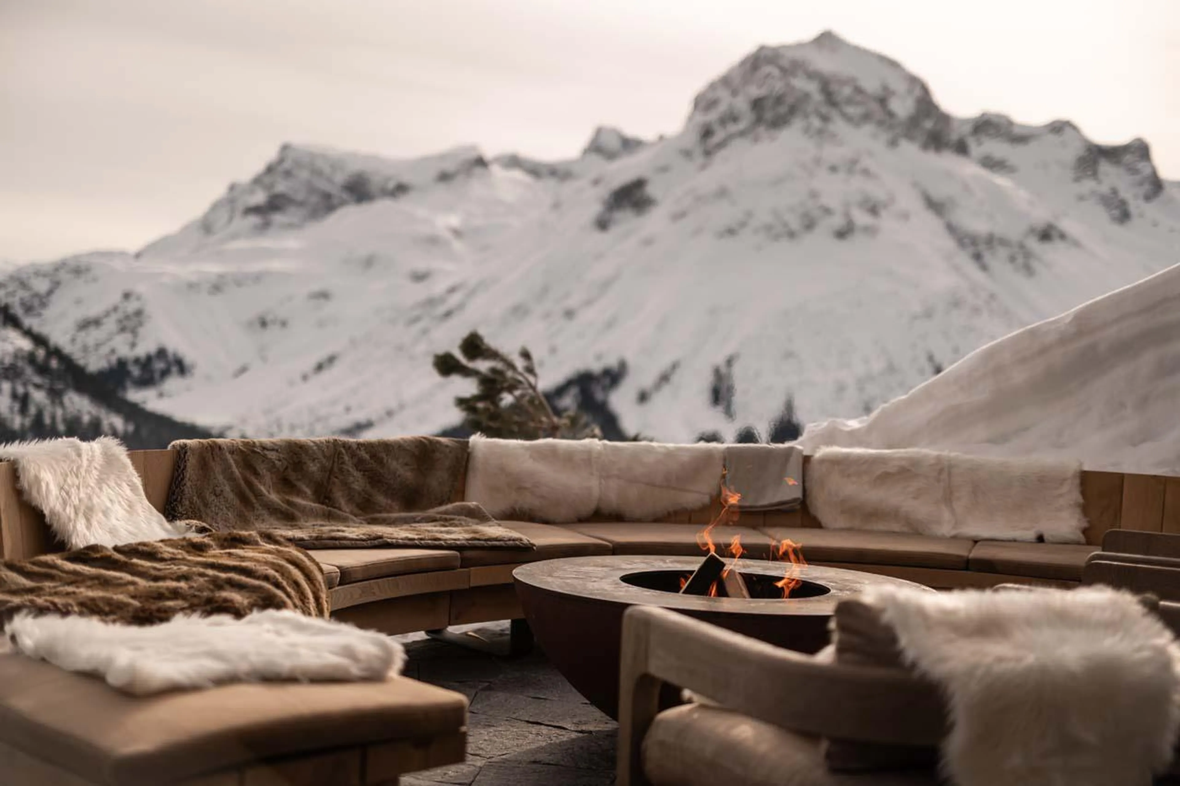 Outdoor seating surrounding the fire at The Barn in Lech