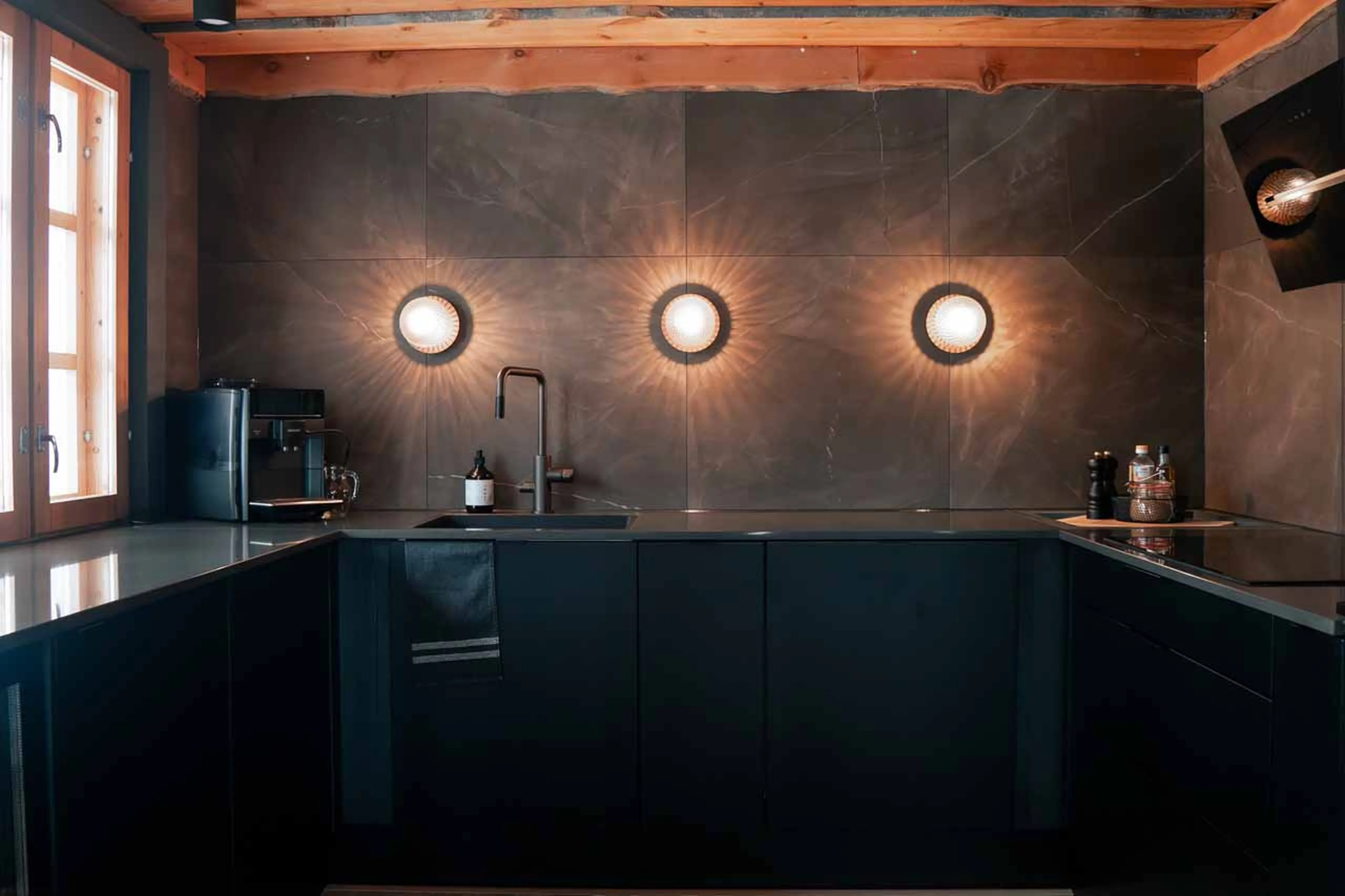 Kitchen with dark facade in The Fell Lodge, Finland