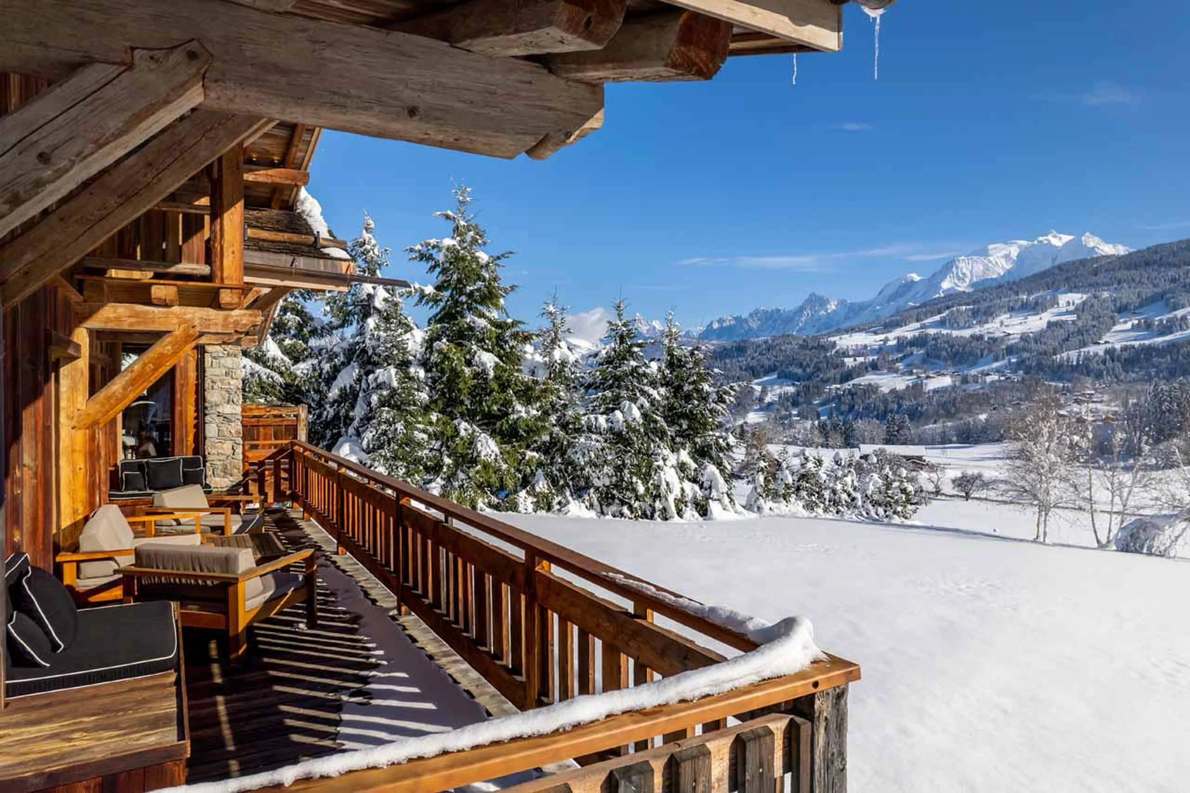 Balcony with panoramic views of the mountain peaks and snow-capped trees at Ultima Megeve