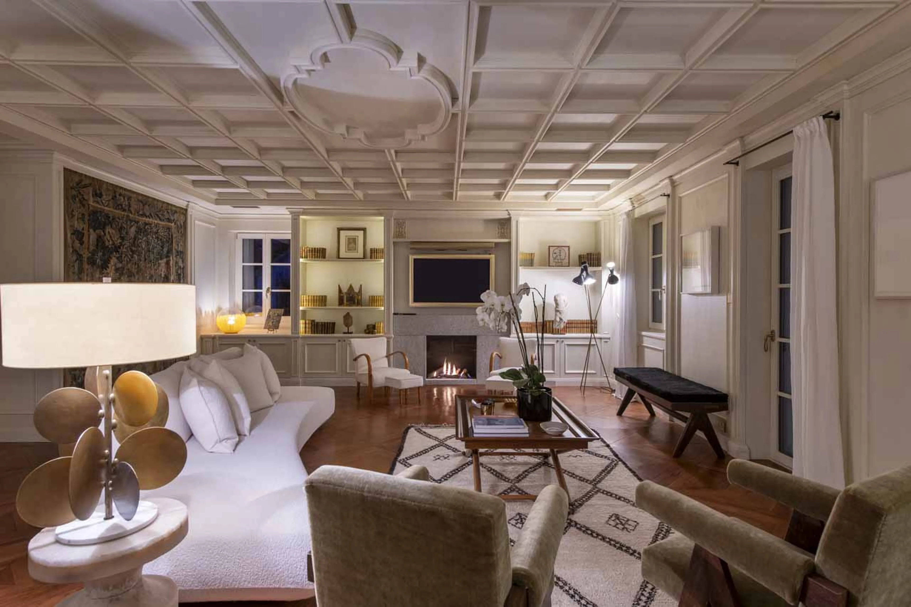 Living area with fireplace at night in Villa Erica 2, St Moritz