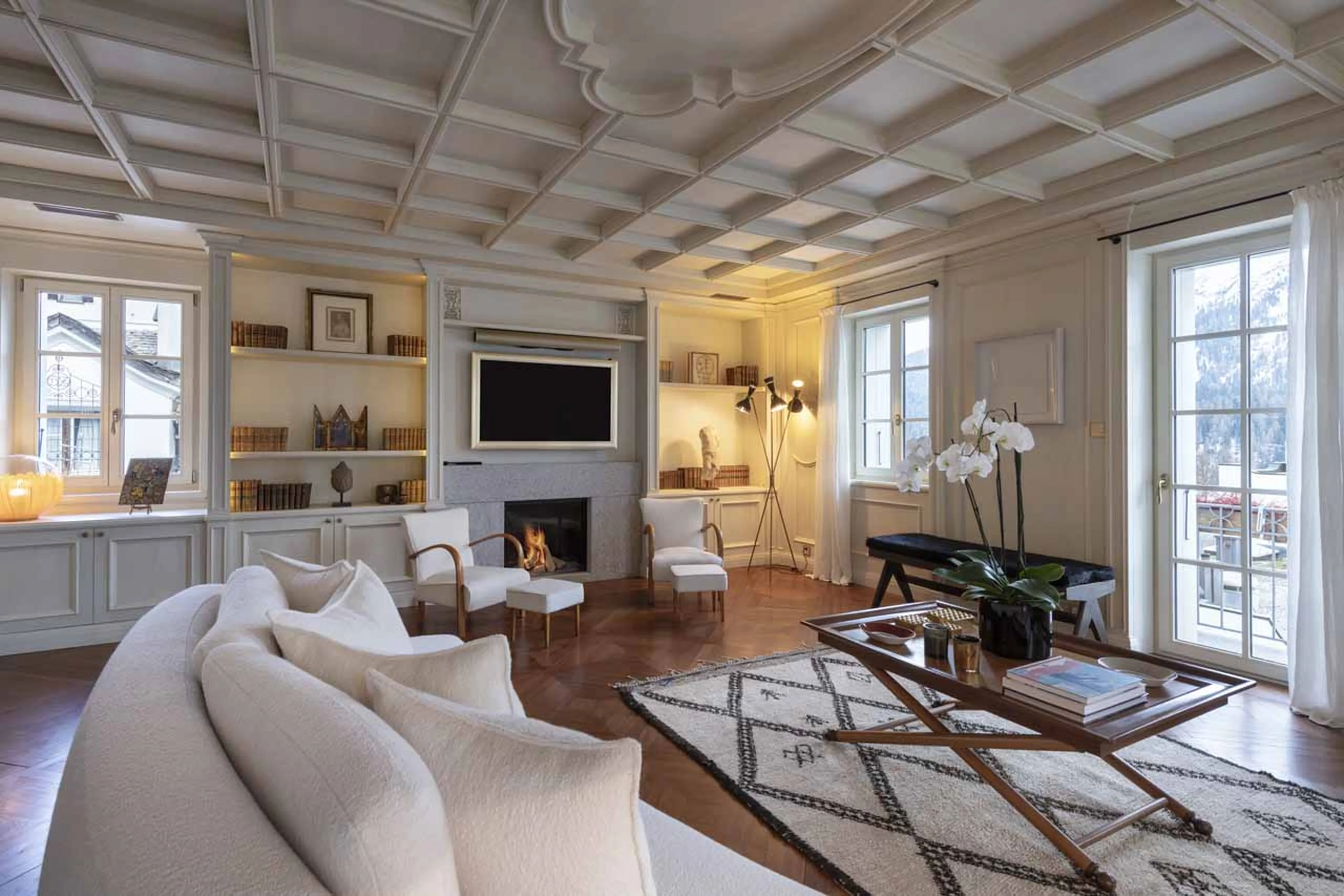 Sofas and coffee table in front of fireplace in Villa Erica 1, St Moritz